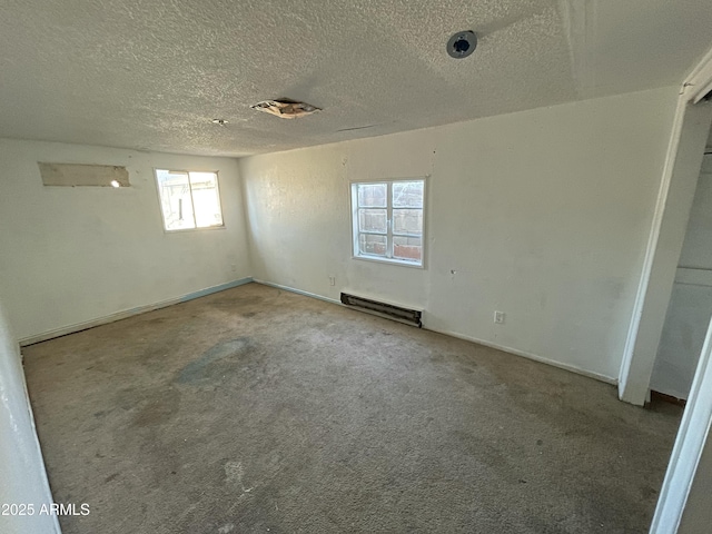 carpeted spare room with a textured ceiling