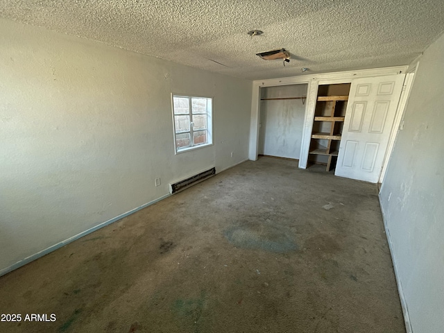 unfurnished bedroom with carpet floors, a baseboard radiator, and a textured ceiling