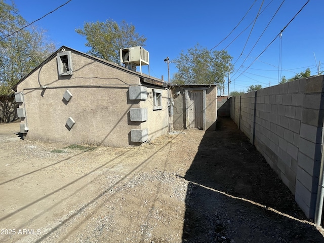 view of property exterior featuring central air condition unit and fence