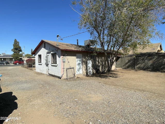 exterior space featuring fence and stucco siding