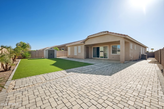 rear view of property featuring a storage unit, a patio area, and central air condition unit