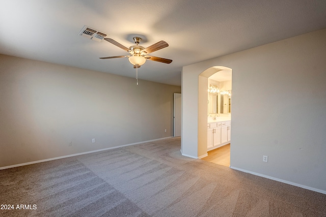 spare room featuring ceiling fan and light colored carpet