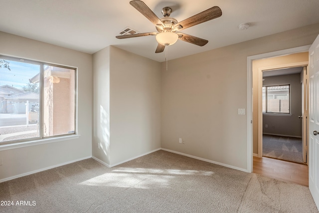 empty room featuring light colored carpet and ceiling fan