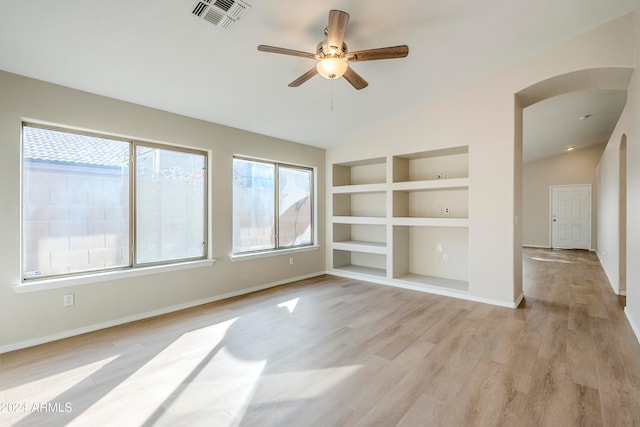 spare room featuring ceiling fan, built in features, light hardwood / wood-style floors, and vaulted ceiling