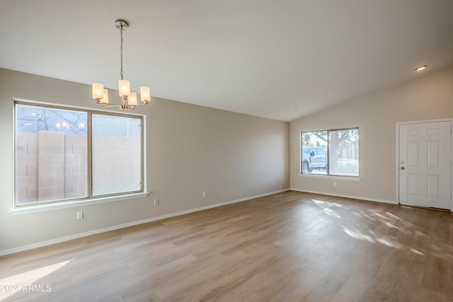 interior space with a notable chandelier, light hardwood / wood-style floors, and lofted ceiling