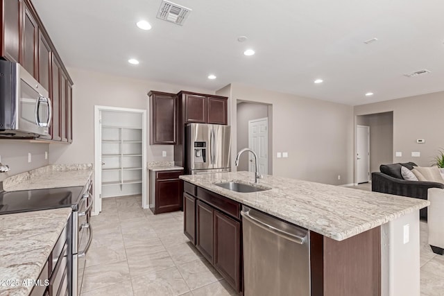 kitchen featuring open floor plan, a sink, stainless steel appliances, and visible vents