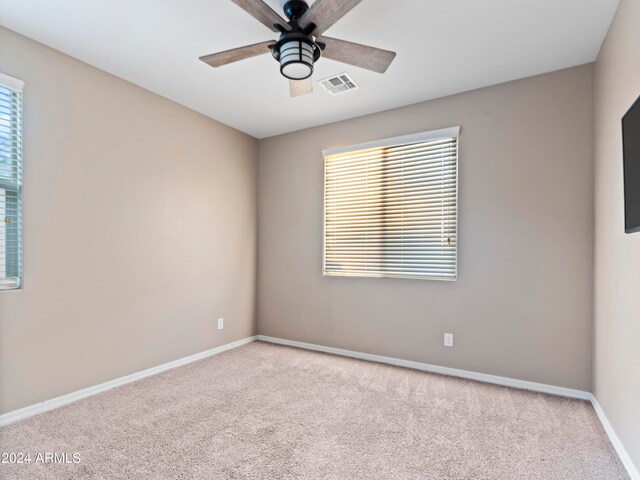 carpeted spare room featuring ceiling fan