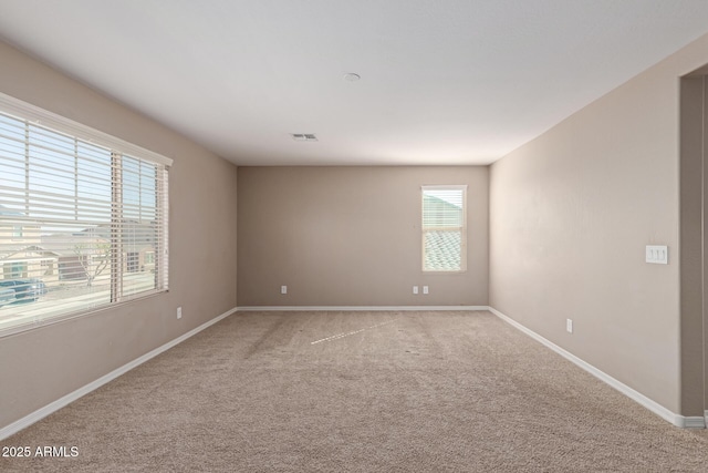 unfurnished room featuring baseboards, visible vents, and light colored carpet