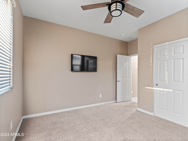 unfurnished bedroom with light carpet and ceiling fan