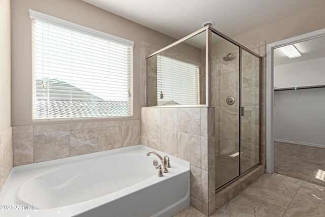 full bathroom featuring a healthy amount of sunlight, marble finish floor, a garden tub, and a stall shower