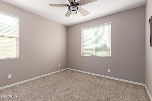 carpeted empty room featuring visible vents, ceiling fan, baseboards, and a healthy amount of sunlight