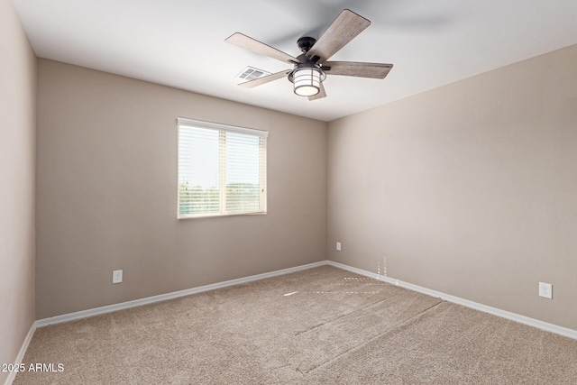 carpeted spare room with visible vents, ceiling fan, and baseboards