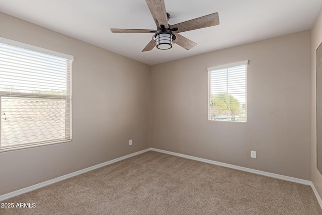 unfurnished room featuring baseboards, a ceiling fan, and carpet