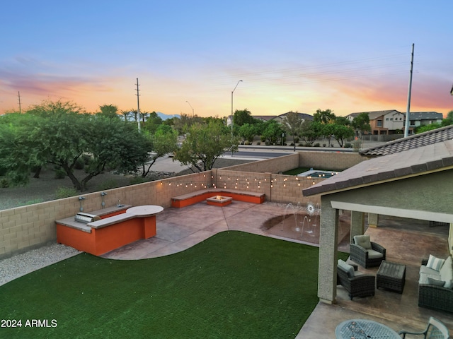 yard at dusk featuring an outdoor hangout area and a patio area