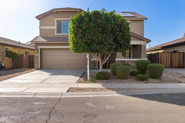 view of front facade with fence, stucco siding, concrete driveway, and an attached garage