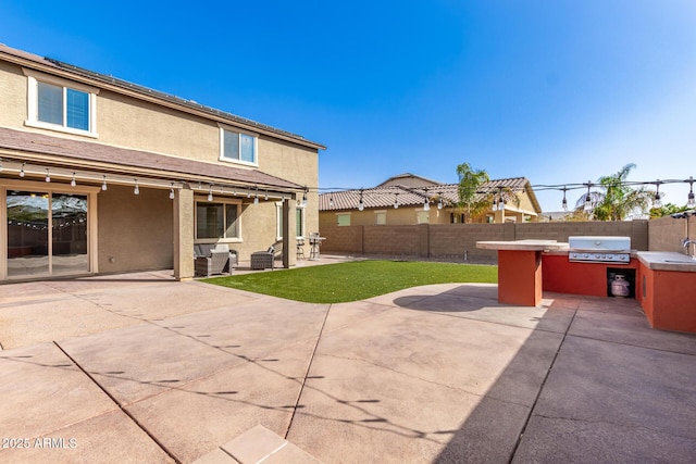 view of patio / terrace featuring an outdoor kitchen, area for grilling, a fenced backyard, and a sink