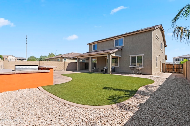 rear view of property featuring a lawn and a patio