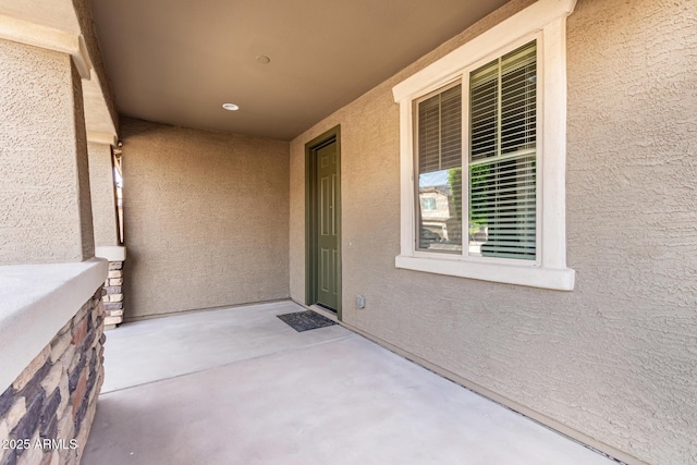 doorway to property featuring stucco siding