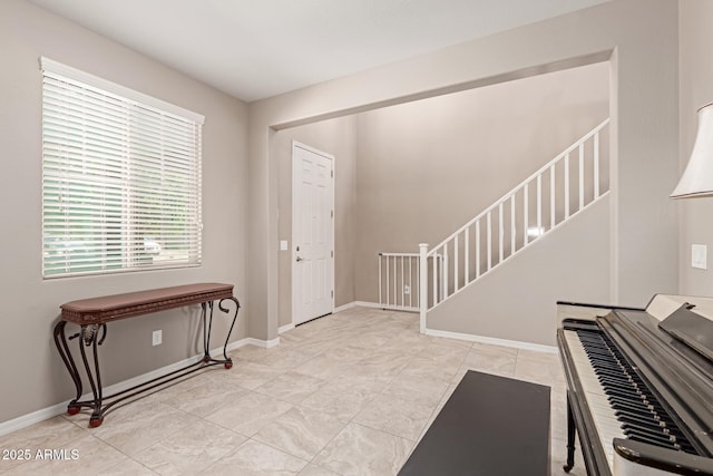 entrance foyer with stairway and baseboards