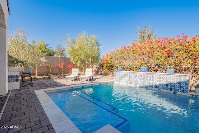 view of pool with a patio and pool water feature