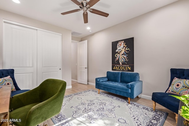 living area featuring light hardwood / wood-style flooring and ceiling fan