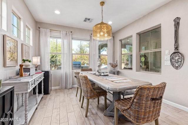 dining space with a notable chandelier and light wood-type flooring