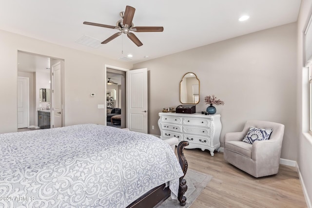 bedroom featuring sink, light hardwood / wood-style flooring, ceiling fan, and ensuite bath