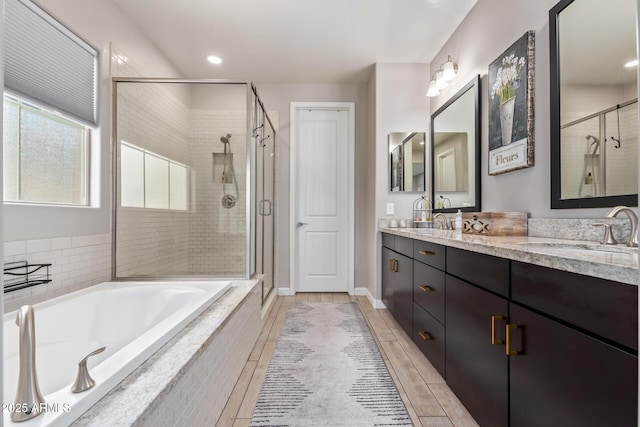 bathroom with vanity and shower with separate bathtub