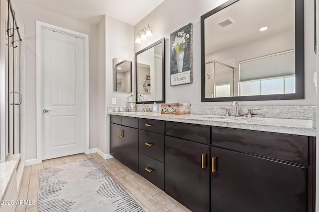 bathroom featuring walk in shower and vanity