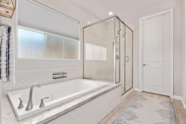 bathroom featuring shower with separate bathtub