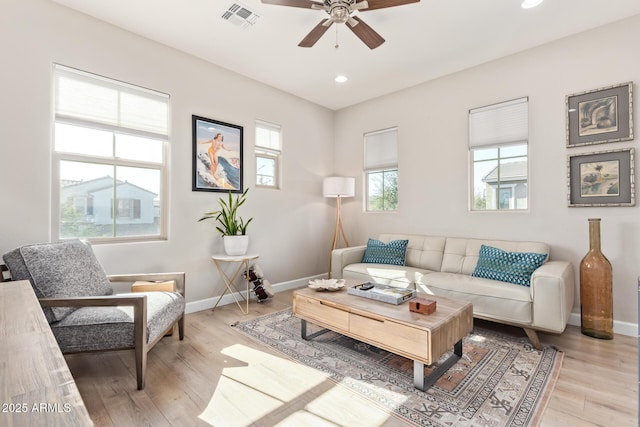 living room with ceiling fan, a healthy amount of sunlight, and light wood-type flooring