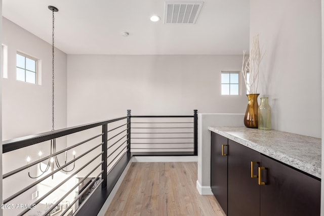 hallway with light hardwood / wood-style floors