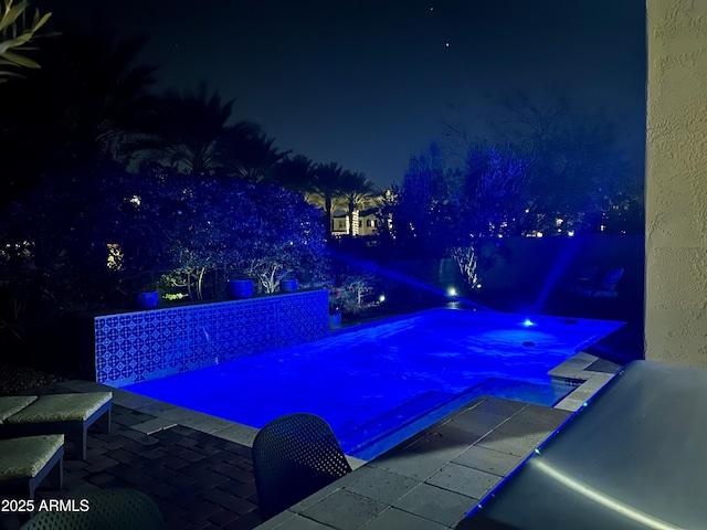 pool at night with a jacuzzi