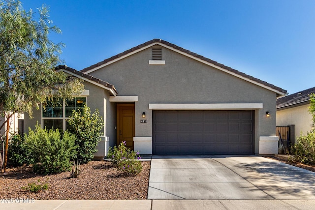 ranch-style house with a garage, stucco siding, concrete driveway, and a tile roof