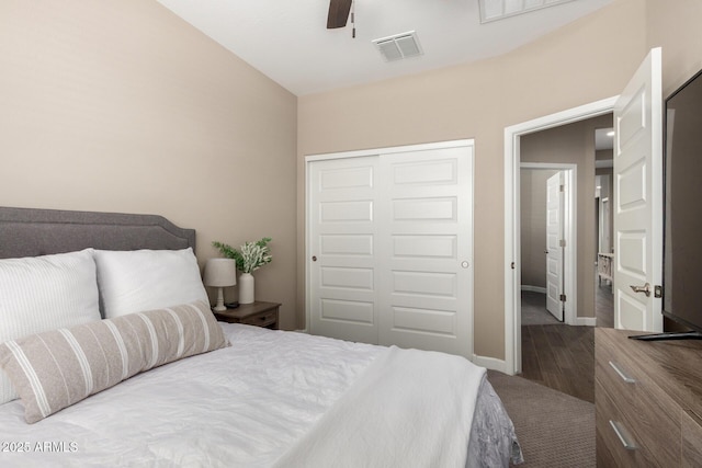 bedroom featuring a ceiling fan, visible vents, wood finished floors, baseboards, and a closet