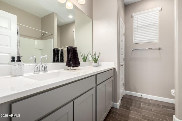 bathroom featuring wood tiled floor, curtained shower, vanity, baseboards, and toilet