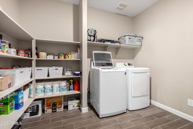 laundry area featuring independent washer and dryer, laundry area, baseboards, and wood tiled floor