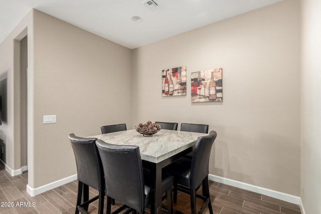 dining space with baseboards, wood finish floors, and visible vents