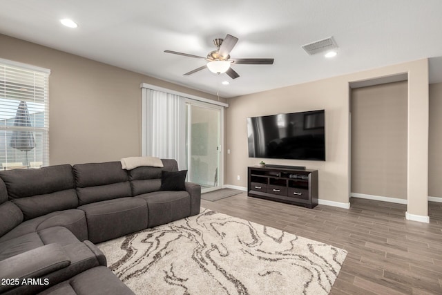 living area featuring a ceiling fan, baseboards, recessed lighting, wood finished floors, and visible vents