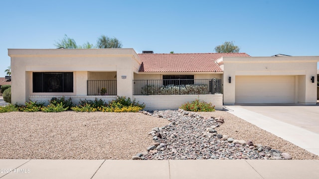 view of front of house featuring driveway, a tiled roof, an attached garage, and stucco siding