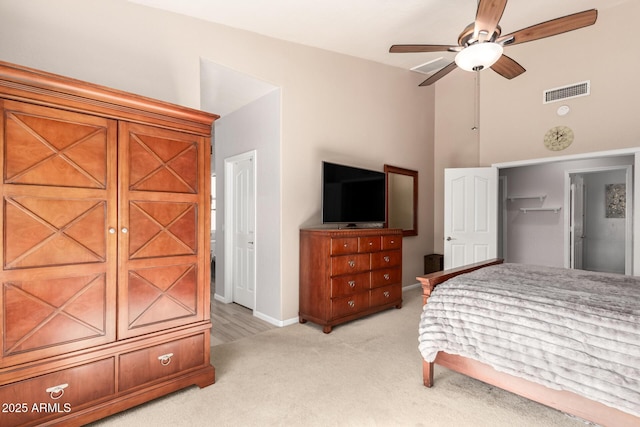 bedroom with lofted ceiling, light colored carpet, a closet, and ceiling fan