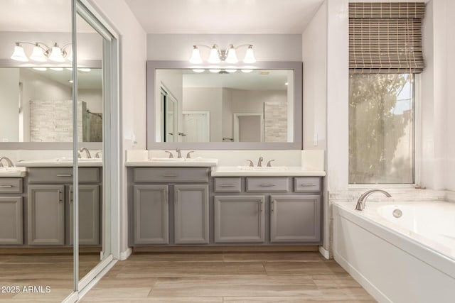 bathroom with vanity, hardwood / wood-style floors, and a bathing tub