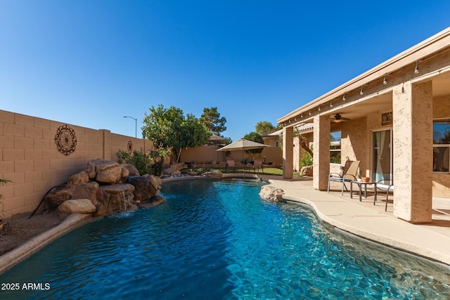 view of swimming pool with a patio, pool water feature, and ceiling fan