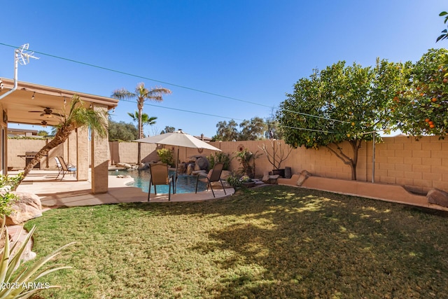 view of yard featuring ceiling fan and a patio