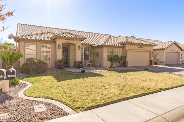 mediterranean / spanish-style house featuring a garage and a front yard