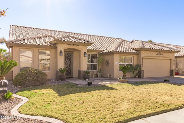 mediterranean / spanish-style home featuring a garage and a front yard