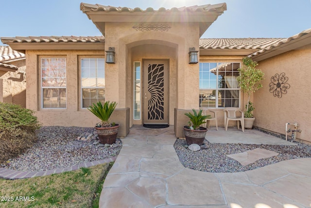 view of exterior entry featuring a patio