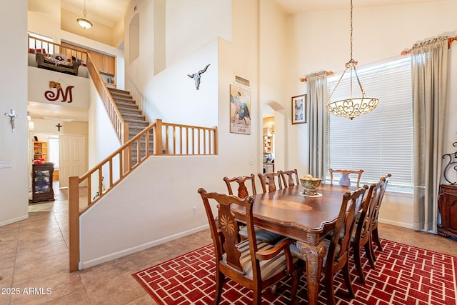 4554 W Detroit St, Chandler, AZ 85226 - dining area featuring baseboards, an inviting chandelier, stairway, light tile patterned floors, and a high ceiling