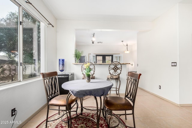 dining area with light tile patterned floors, visible vents, and baseboards