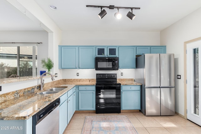 kitchen featuring blue cabinets, glass insert cabinets, a sink, and black appliances